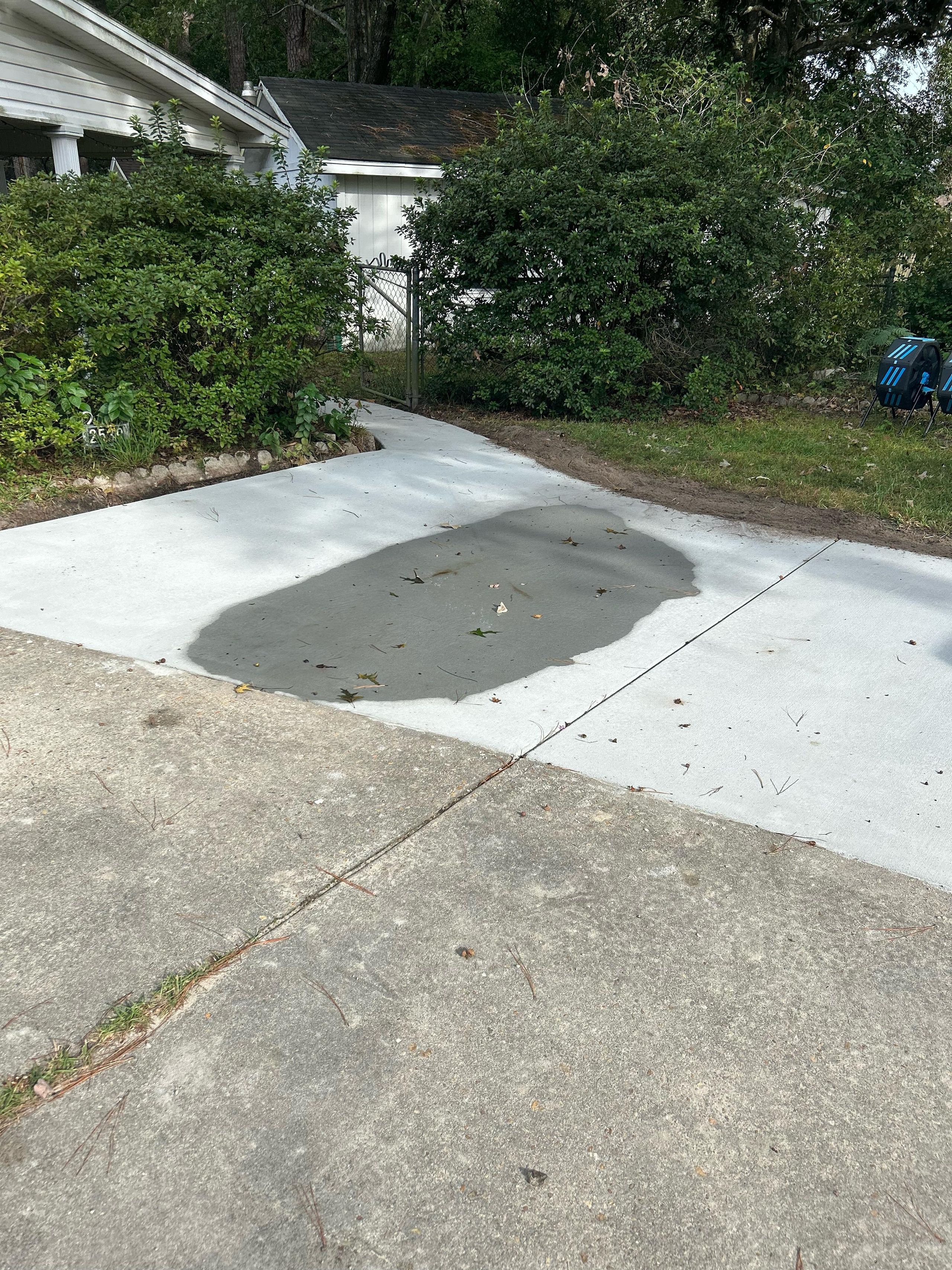 Water pooling on concrete driveway showing drainage problems