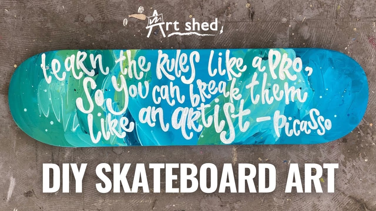 Artist applying marker art to skateboard deck showing technique and detail work